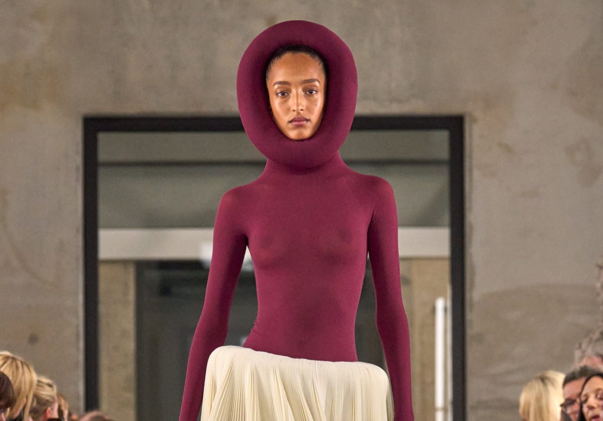 Modelo en la pasarela del desfile de Alaïa en París Fashion Week 2025, luciendo un diseño de silueta escultórica con detalles vanguardistas. La colección fusiona estructuras innovadoras con la esencia atemporal de la casa de moda.