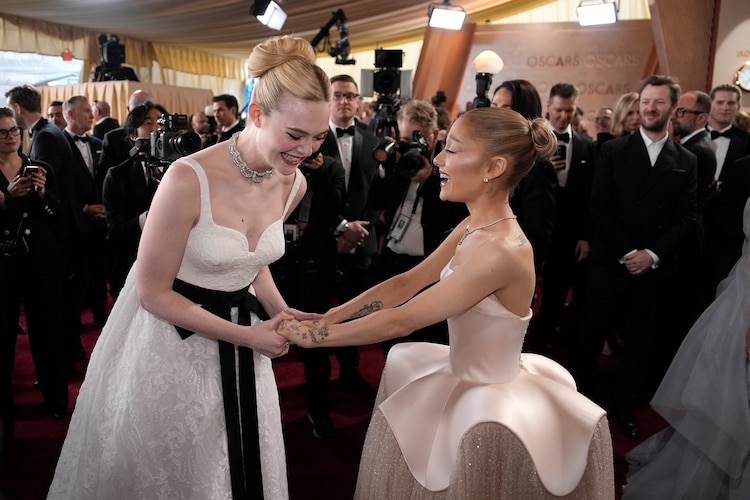 Elle Fanning y Ariana Grande compartiendo un momento en la alfombra roja de los Oscar 2025, con looks elegantes y sofisticados.